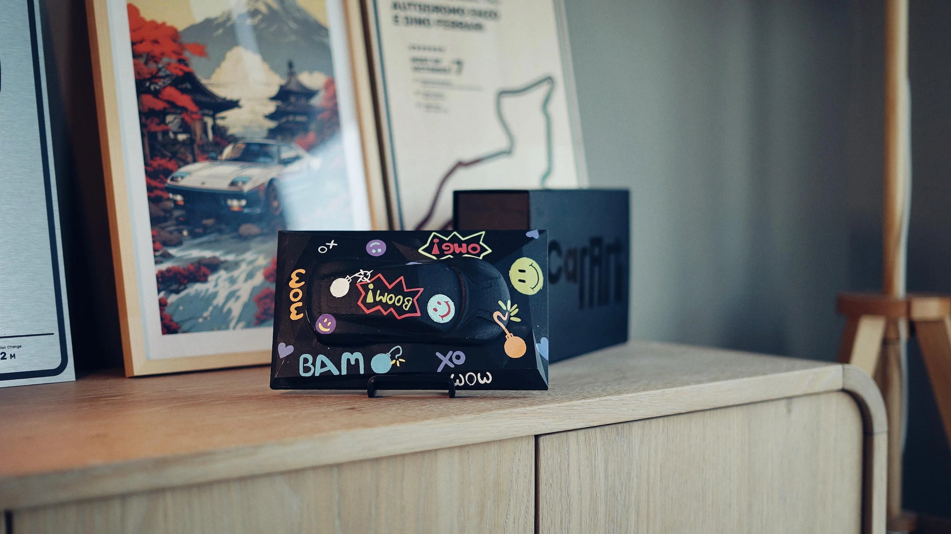 Lotus Emira concrete sculpture art mockup in black pop art graffiti style with comic lettering and emojis, landscape display by CarArt Dubai