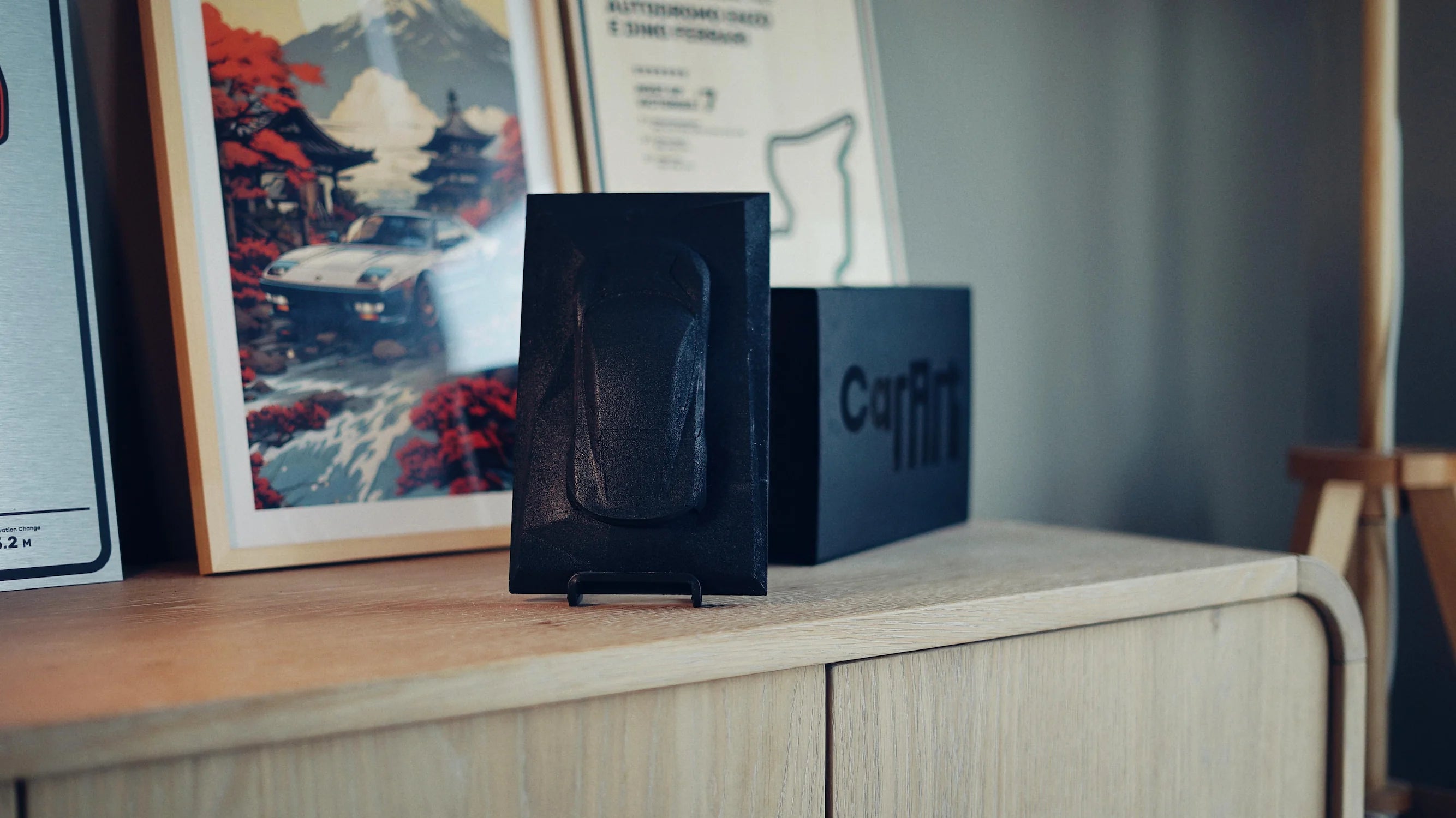 Lotus Emira concrete sculpture art mockup in deep black minimal finish, portrait display by CarArt Dubai